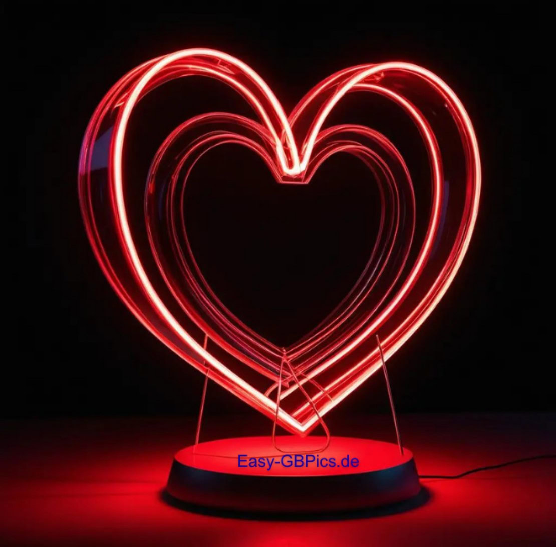 Herzen GB-Bild<br />
Eine herzförmige LED-Lichtskulptur in leuchtendem Rot hebt sich von einem pechschwarzen Hintergrund ab. Drei übereinander gestapelte Herzen erzeugen einen coolen 3D-Effekt. Die Skulptur steht auf einem runden, rot beleuchteten Sockel.